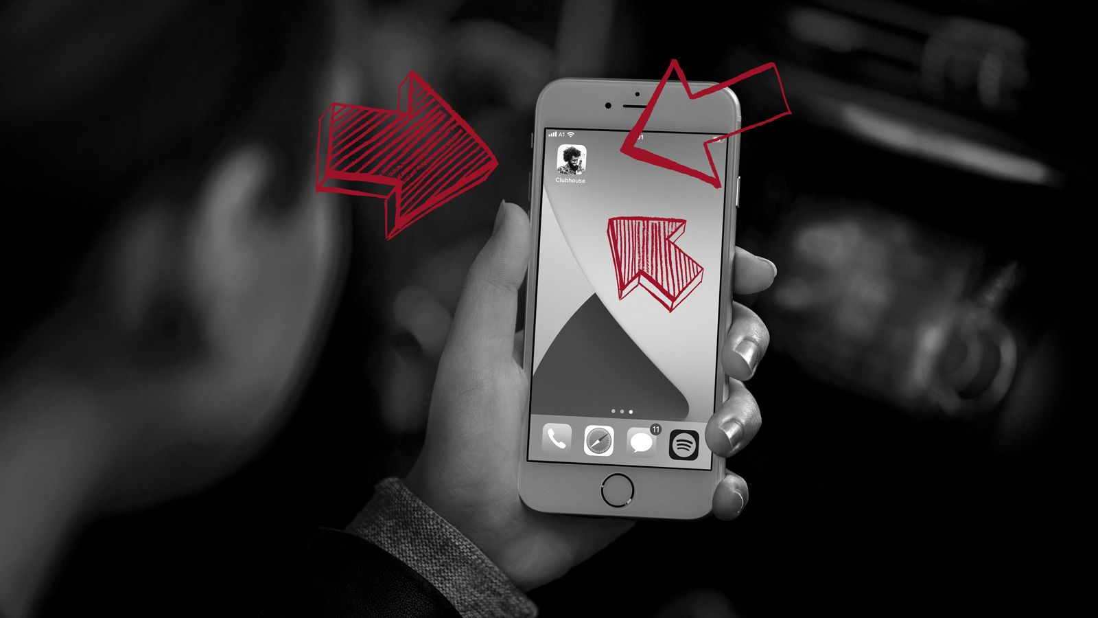 Graues Smartphone in einer Hand mit roten Pfeilen auf Profilbild bei Clubhouse zeigend