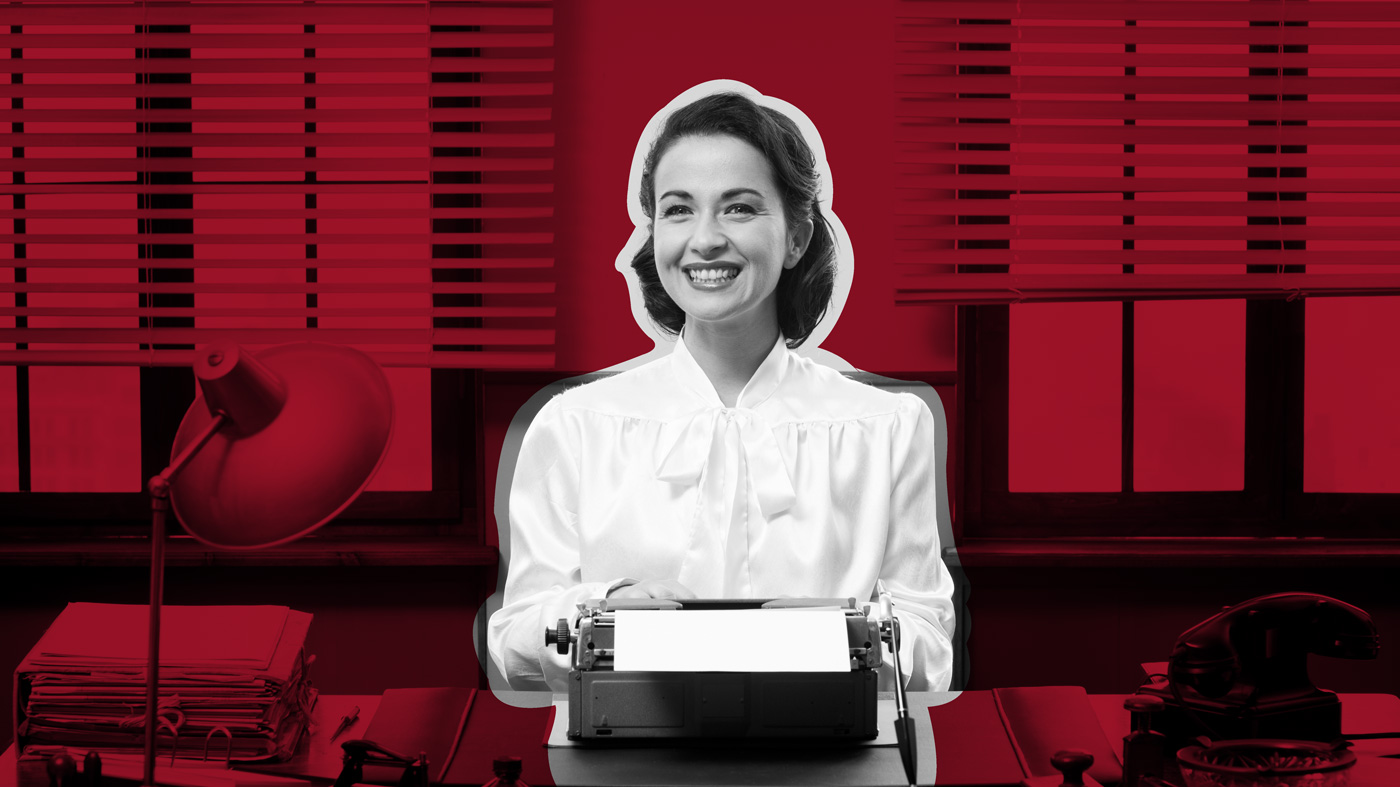 Frau mit weißer altmodischer Bluse tippt auf Schreibmaschine auf rotem Buero-Hintergrund